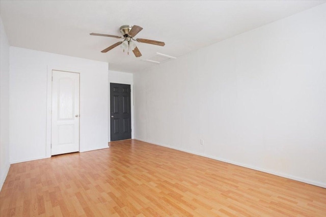 unfurnished room featuring light wood-style floors, attic access, and baseboards