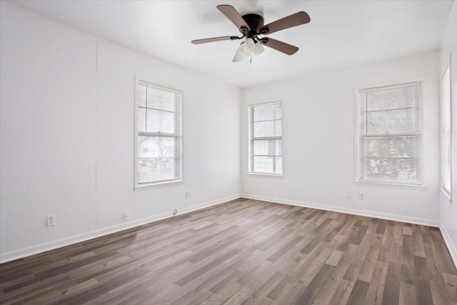 empty room with ceiling fan, wood finished floors, and baseboards