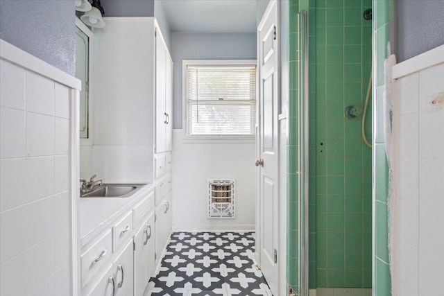 full bathroom featuring tile walls, heating unit, vanity, a shower stall, and tile patterned floors