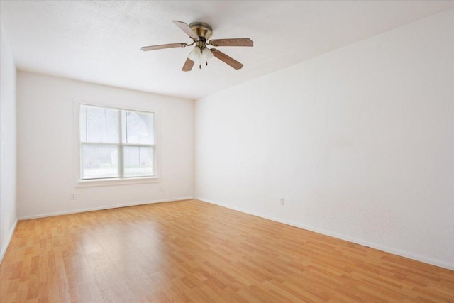 spare room featuring light wood-style floors, ceiling fan, and baseboards