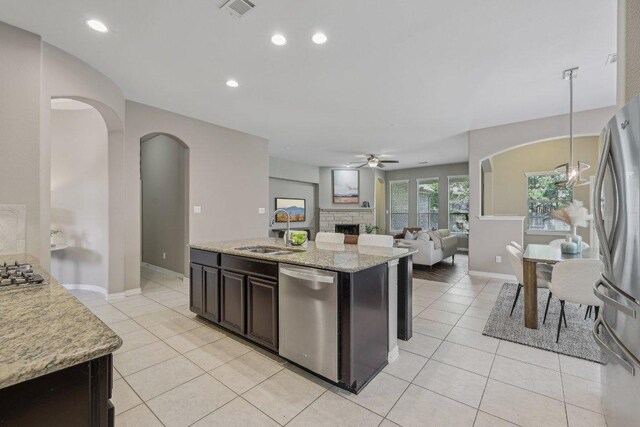 2629 Estefania Ln, Round Rock, TX 78665 - kitchen with stainless steel appliances, arched walkways, a sink, ceiling fan, and light tile patterned floors