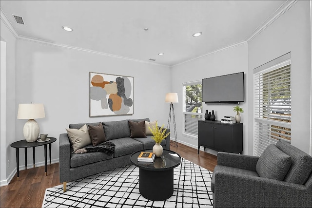 living room with visible vents, crown molding, and wood finished floors