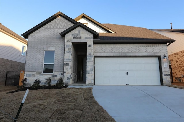 view of front of house with a shingled roof, concrete driveway, stone siding, an attached garage, and brick siding