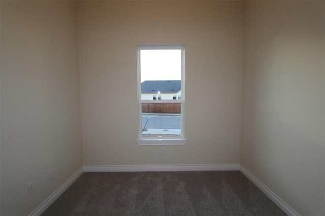 carpeted empty room featuring baseboards