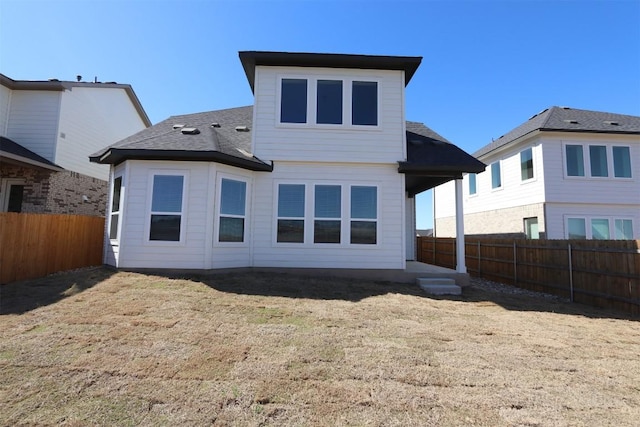 rear view of house featuring a patio area, a fenced backyard, and a lawn