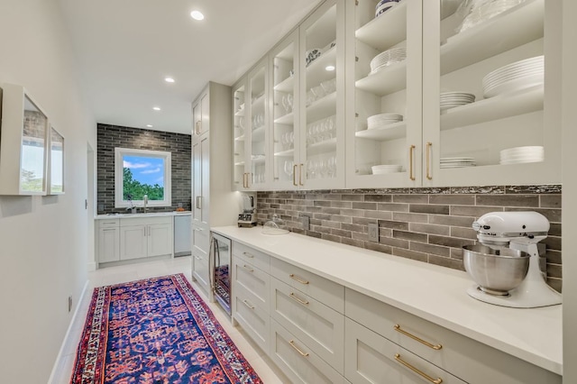 bar with tasteful backsplash, wine cooler, recessed lighting, light tile patterned flooring, and a sink