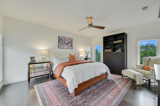 bedroom with visible vents, baseboards, dark wood-type flooring, and ceiling fan