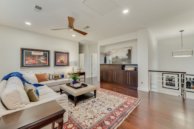 living area with recessed lighting, visible vents, baseboards, and dark wood finished floors