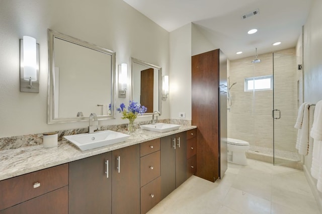 24710 Fossil Trl, Spicewood, TX 78669 - bathroom featuring a shower stall, double vanity, toilet, and tile patterned flooring