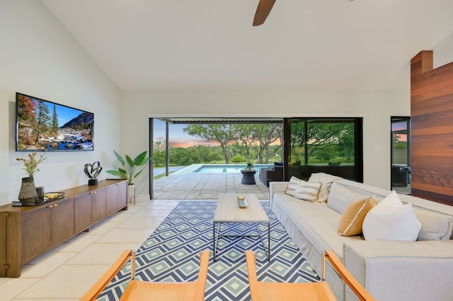 living room featuring lofted ceiling, light tile patterned floors, a ceiling fan, and a sunroom