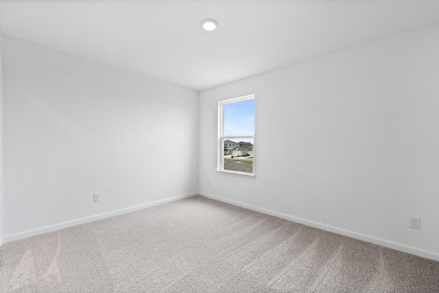 carpeted spare room with baseboards