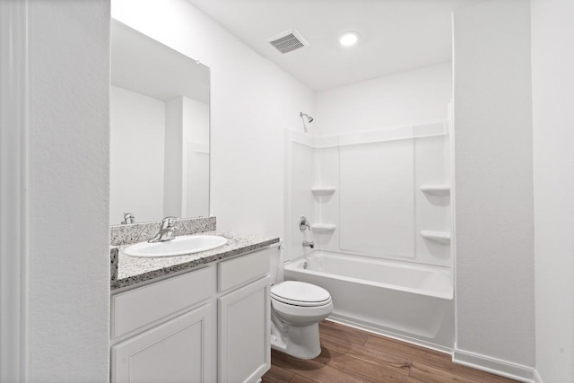 full bathroom with visible vents, toilet, vanity, wood finished floors, and shower / bathtub combination