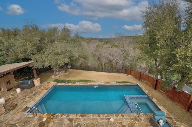 view of pool featuring a yard, a fenced backyard, and a pool with connected hot tub