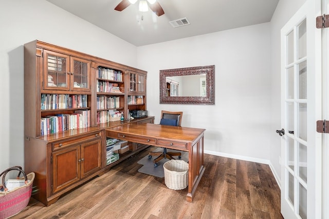 home office featuring a ceiling fan, visible vents, baseboards, and wood finished floors