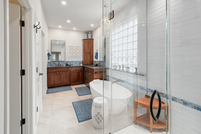 full bath with a stall shower, a soaking tub, vanity, and tile patterned floors