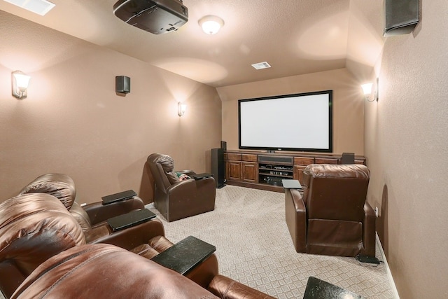 home theater room featuring carpet floors, visible vents, and a textured wall