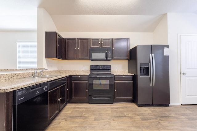 kitchen featuring black appliances, light wood-style flooring, dark brown cabinets, and a sink