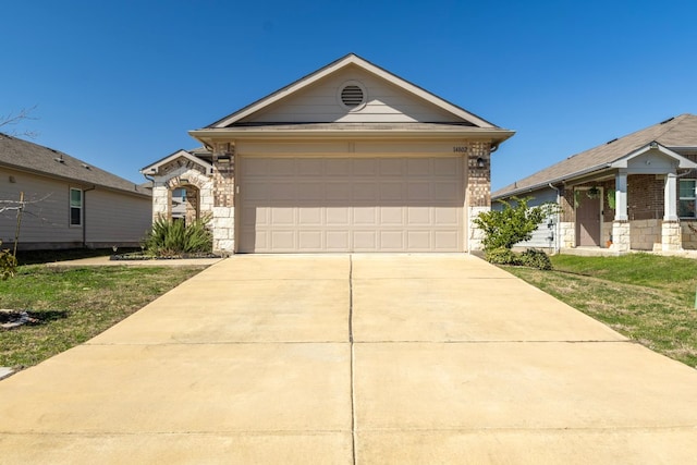 view of front of property with a garage, stone siding, a front lawn, and concrete driveway