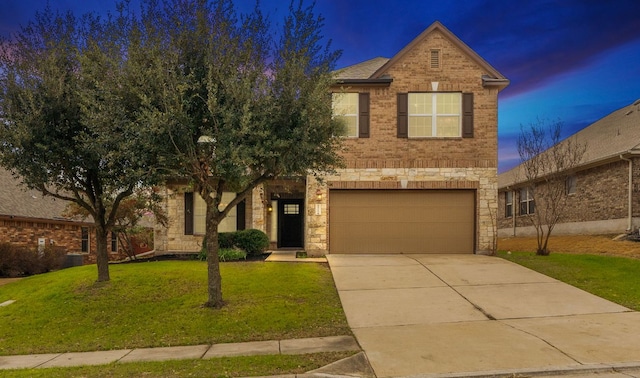 traditional home featuring an attached garage, brick siding, driveway, stone siding, and a front lawn