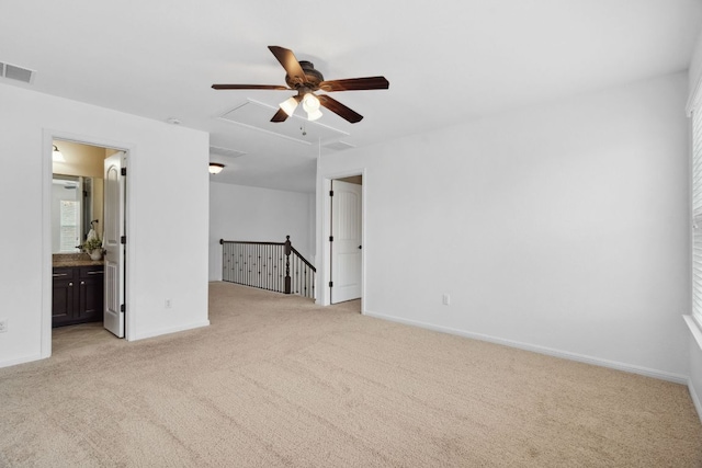 empty room featuring light carpet, baseboards, visible vents, and attic access