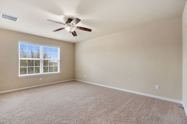 carpeted empty room featuring a ceiling fan, visible vents, and baseboards