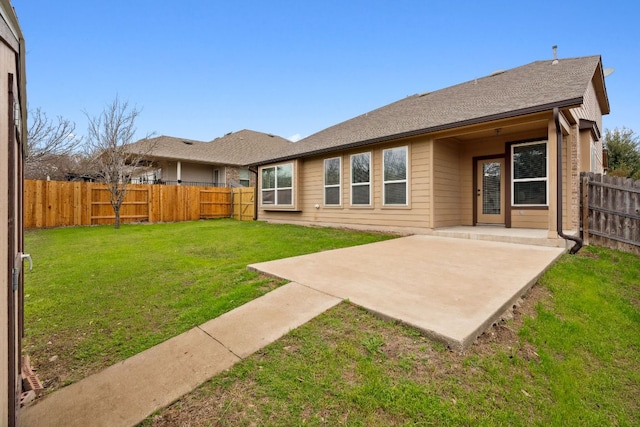 back of property featuring a patio area, a yard, a fenced backyard, and roof with shingles