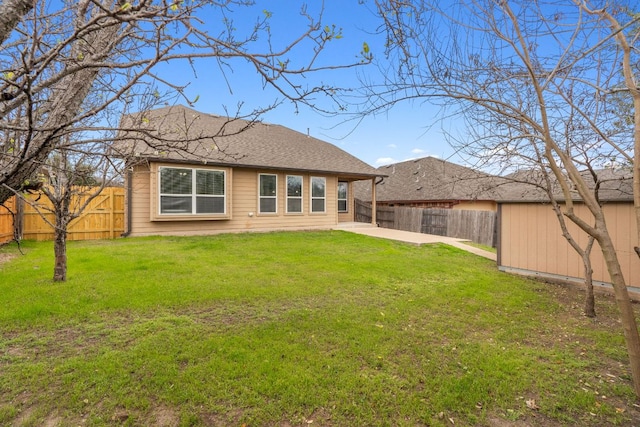 rear view of house featuring a fenced backyard, a patio, a lawn, and an outdoor structure