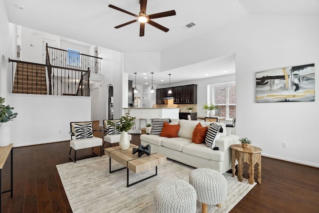 living area featuring visible vents, arched walkways, ceiling fan, wood finished floors, and high vaulted ceiling