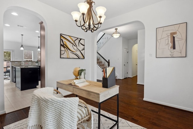 office featuring arched walkways, recessed lighting, visible vents, wood finished floors, and baseboards