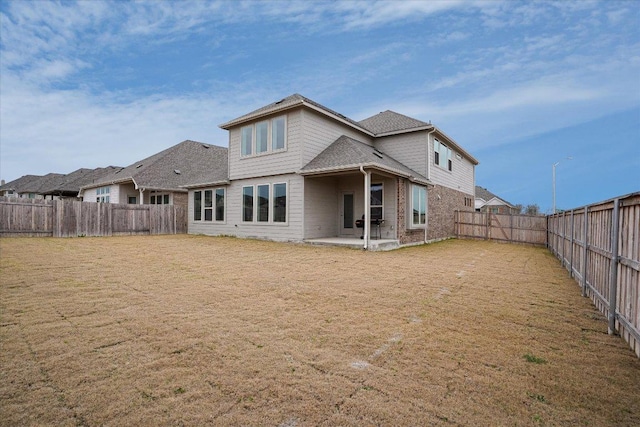 back of property with a patio area, a fenced backyard, a lawn, and brick siding