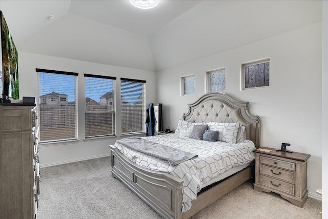 bedroom featuring lofted ceiling, light carpet, and baseboards