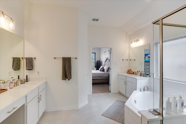 ensuite bathroom featuring lofted ceiling, visible vents, vanity, and a bath