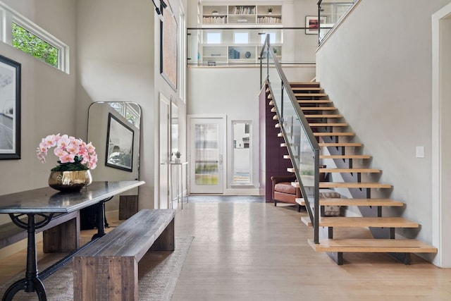 entryway featuring a high ceiling, stairway, and wood finished floors