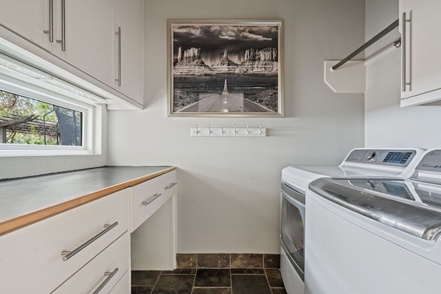 laundry area with cabinet space, stone finish floor, and separate washer and dryer