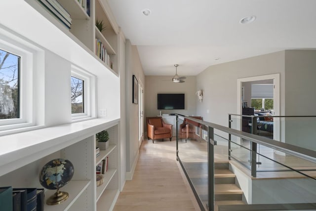 hallway featuring light wood-style flooring and baseboards