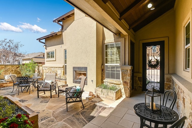 view of patio with a lit fireplace