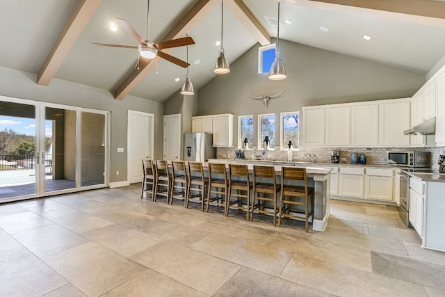 kitchen with decorative backsplash, appliances with stainless steel finishes, high vaulted ceiling, beamed ceiling, and under cabinet range hood