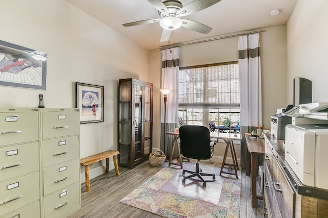 office area with a ceiling fan, baseboards, and wood finished floors