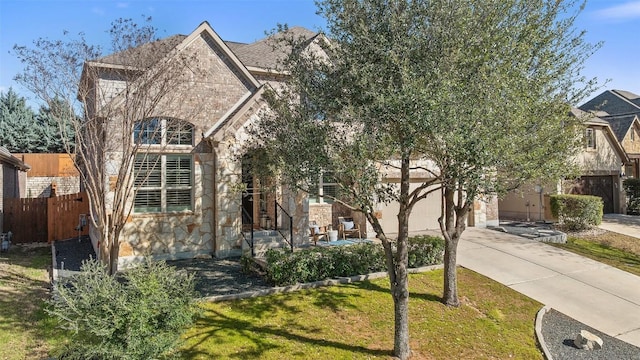 view of front facade featuring a garage, concrete driveway, stone siding, fence, and a front lawn