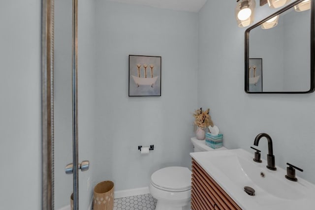 bathroom featuring vanity, tile patterned flooring, toilet, and baseboards