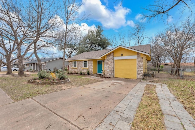 view of front of property featuring an attached garage, a shingled roof, fence, driveway, and stone siding