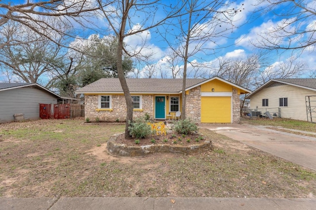 single story home with an attached garage, a shingled roof, fence, driveway, and stone siding