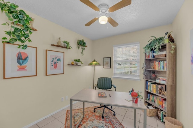 office area with a ceiling fan, tile patterned flooring, a textured ceiling, and baseboards