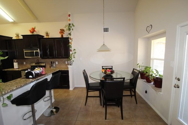 dining area featuring light tile patterned flooring, visible vents, and baseboards