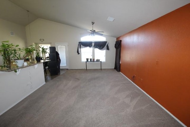 empty room featuring vaulted ceiling, ceiling fan, carpet, and visible vents