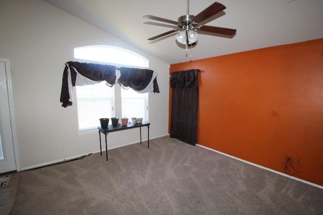 spare room featuring vaulted ceiling, ceiling fan, and carpet flooring