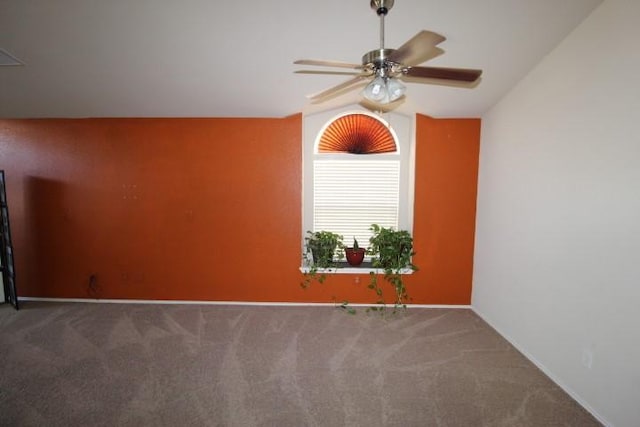 unfurnished room with carpet, baseboards, vaulted ceiling, and a ceiling fan