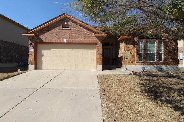 single story home featuring stone siding, concrete driveway, brick siding, and an attached garage