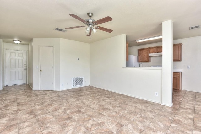 unfurnished living room with baseboards, visible vents, and a ceiling fan