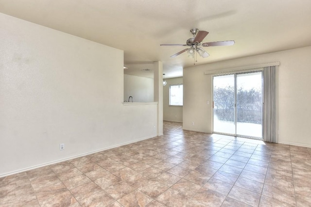 spare room featuring ceiling fan and baseboards